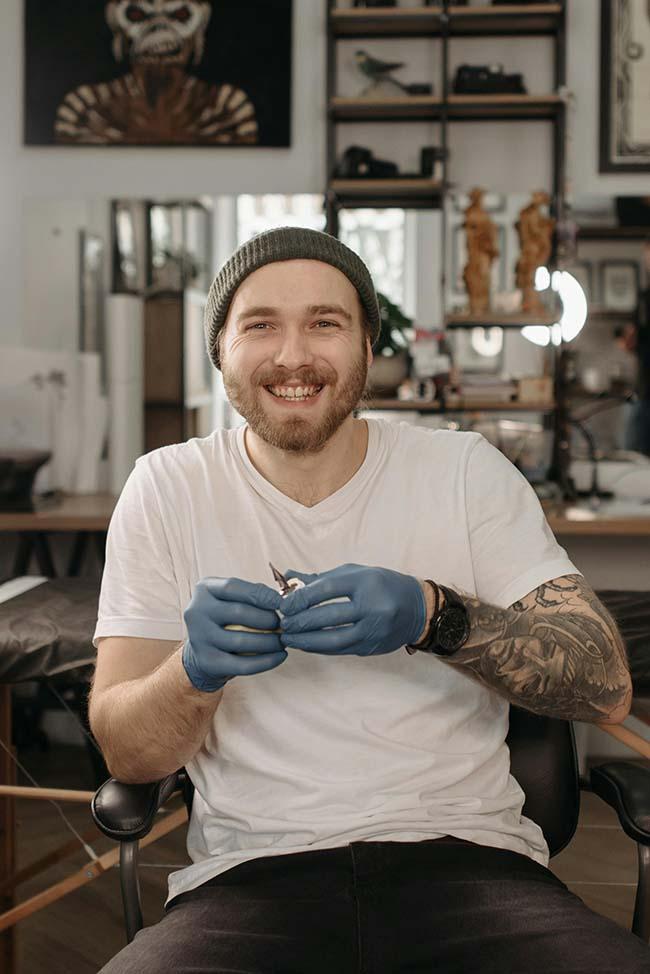 Happy Tattoo Artist Holding a Tattoo Machine