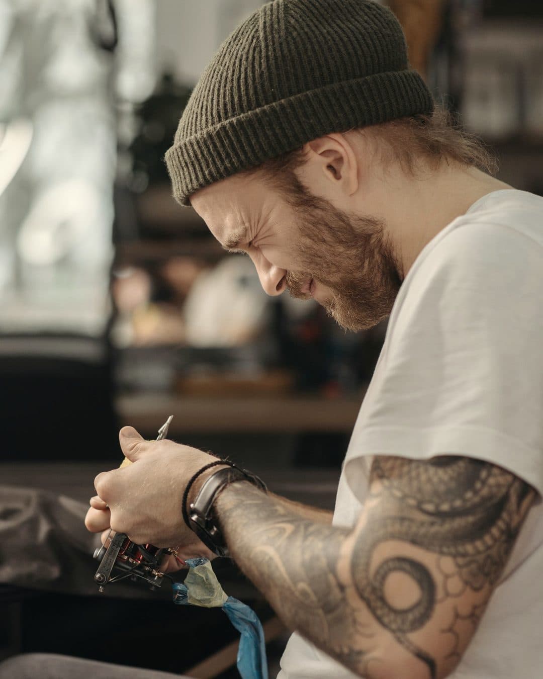 Un tatuatore concentrato sulla sua macchinetta in studio