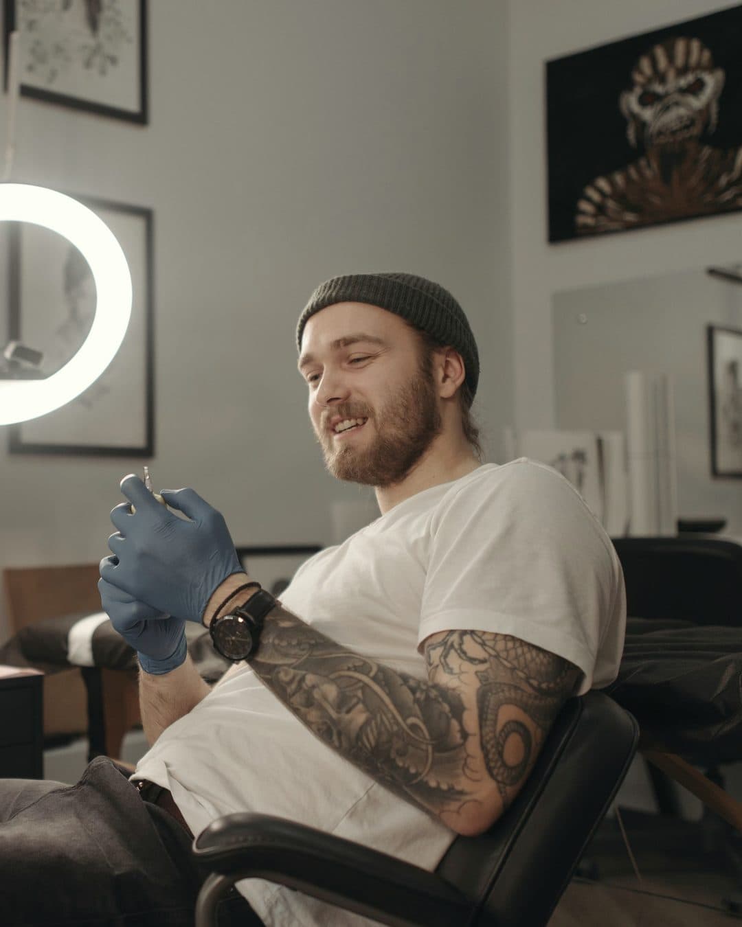 A tattoo artist smiling at his station in a bright studio